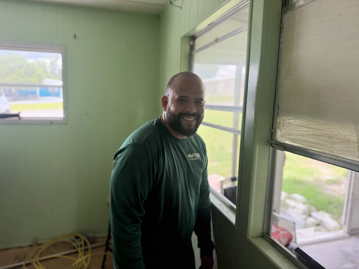 Mister Safety electrician in a green company shirt on a home rewiring job in Brooksville, Florida